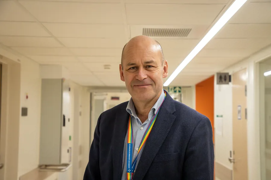 nærbilde av Øystein Mæland som står i en sykehuskorridor