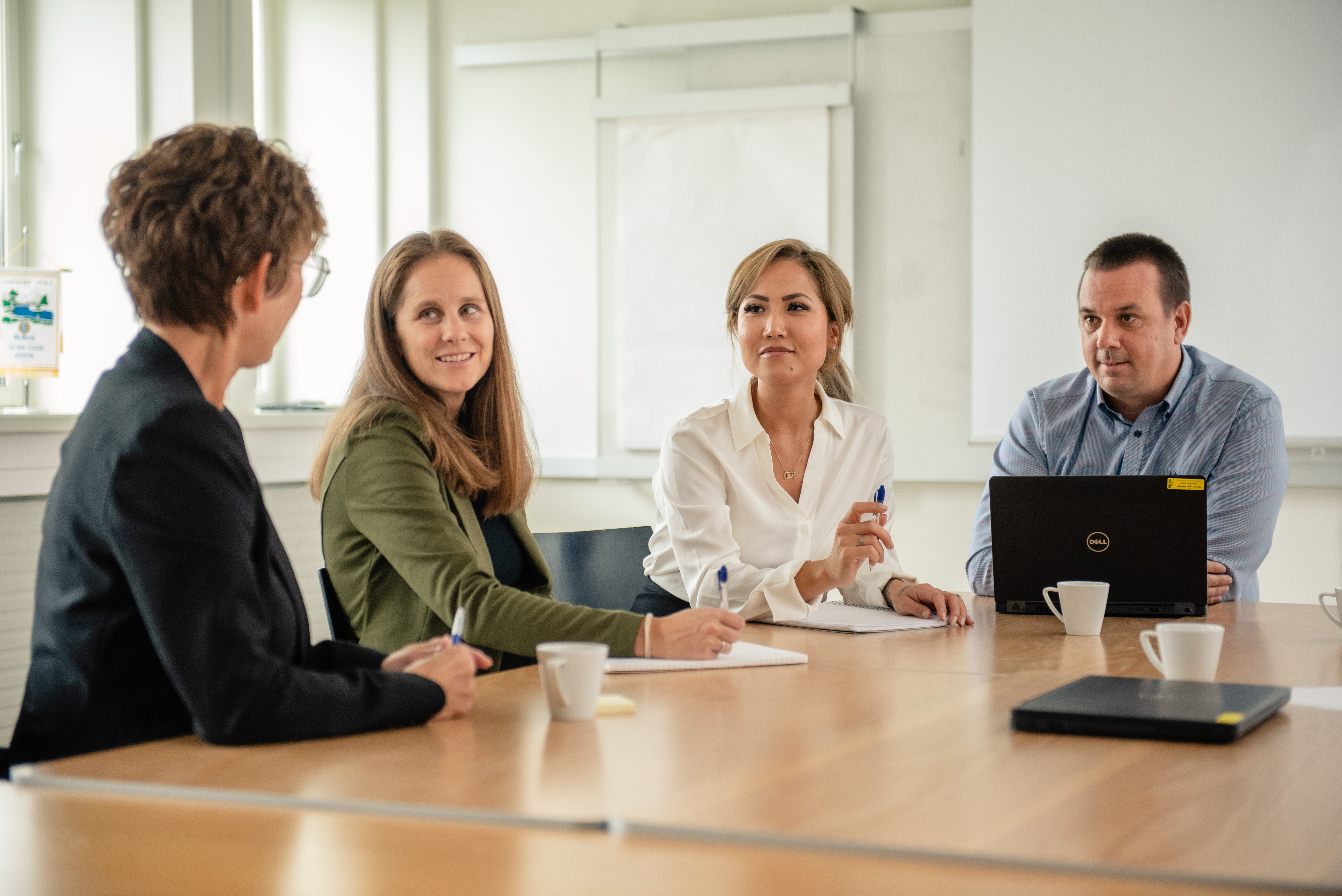 Fire mennesker rundt et møtebord