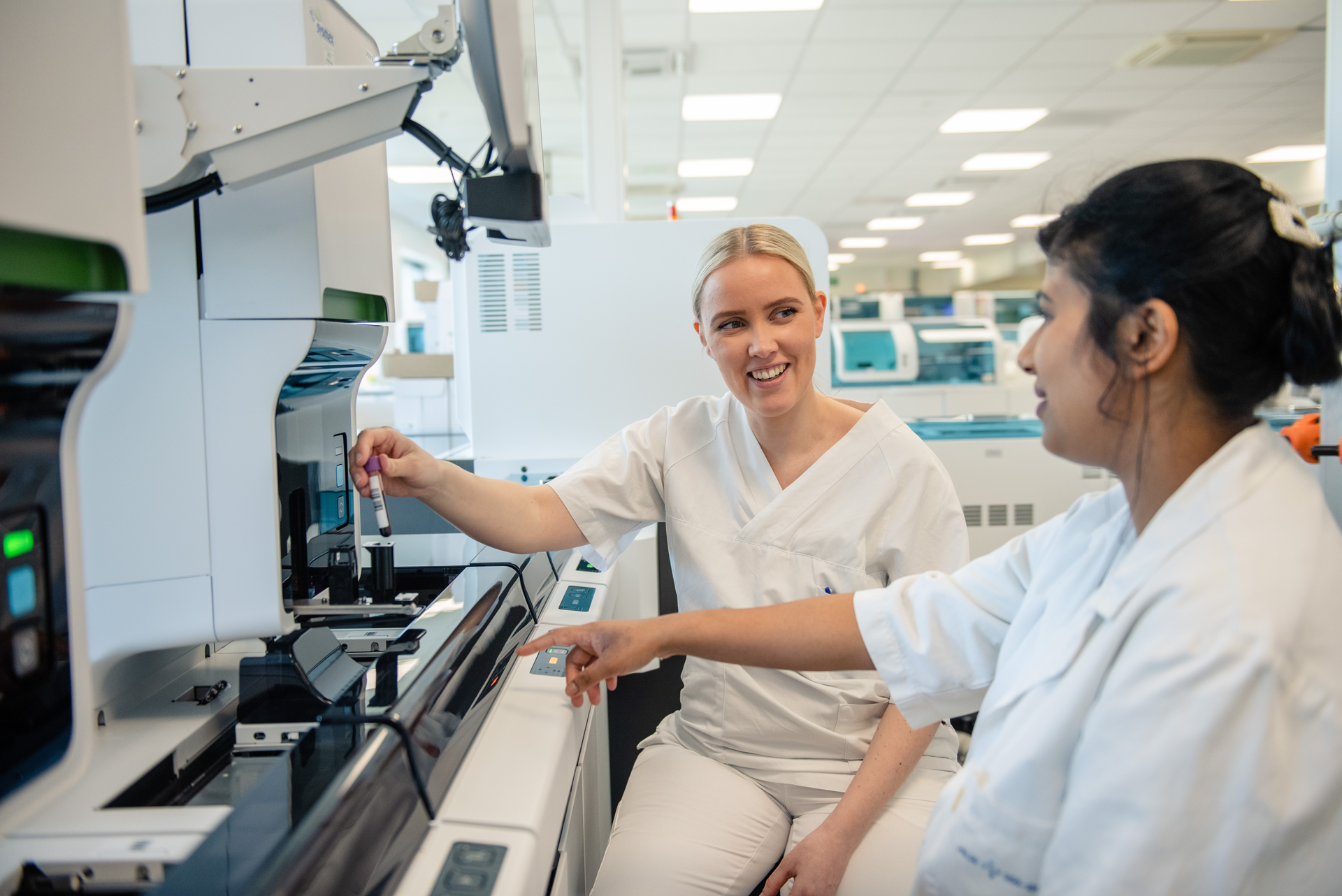 En kvinne som viser en mann noe på datamaskinen