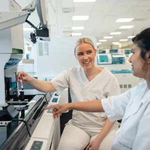 A woman showing a man something on the computer