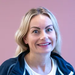 En kvinne som smiler til kameraet