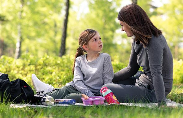 A couple of women sitting on the grass