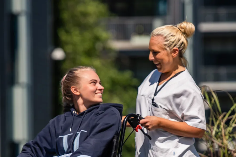 A woman pushing a girl in a wheelchair