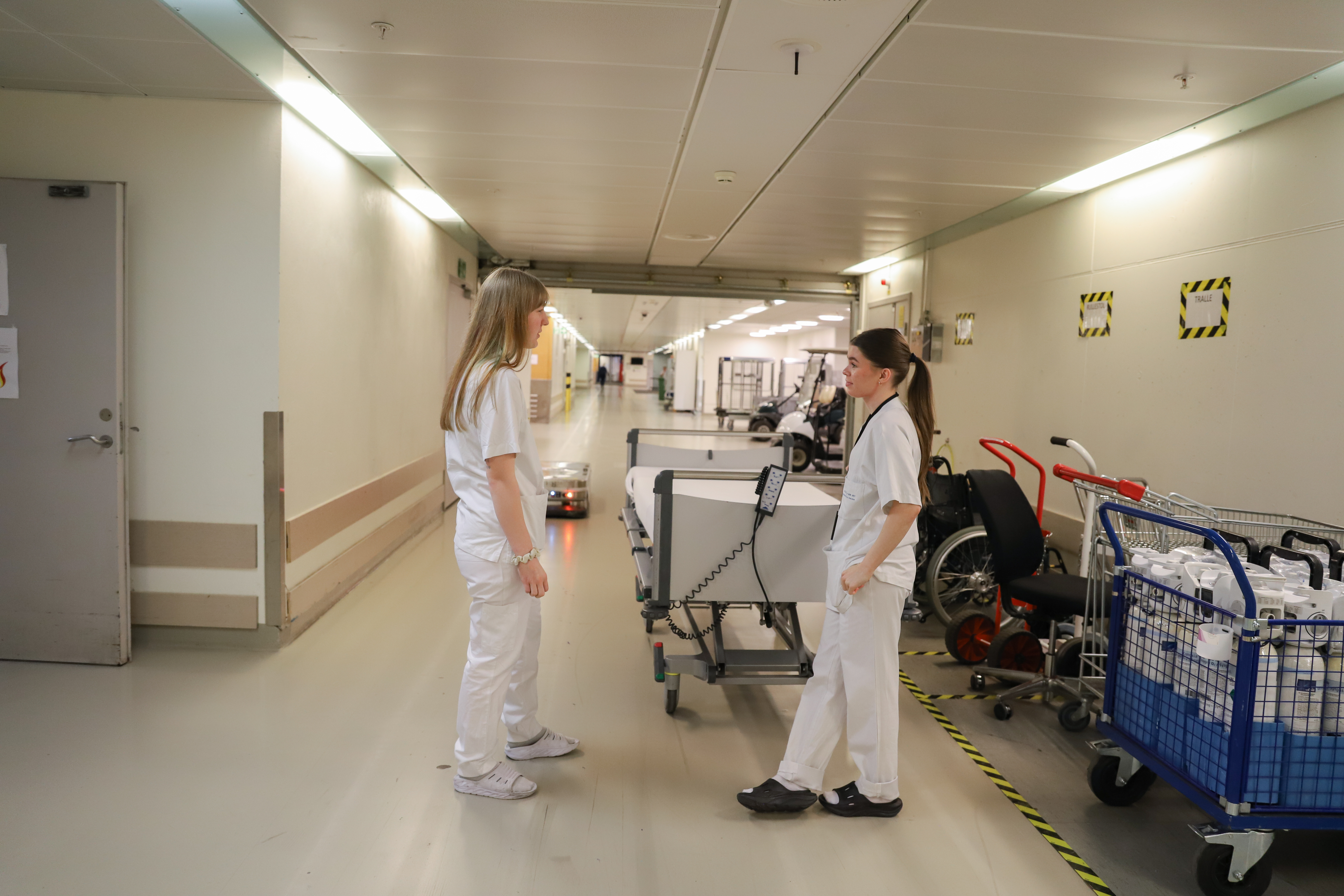 to kollegaer prater sammen i en korridor