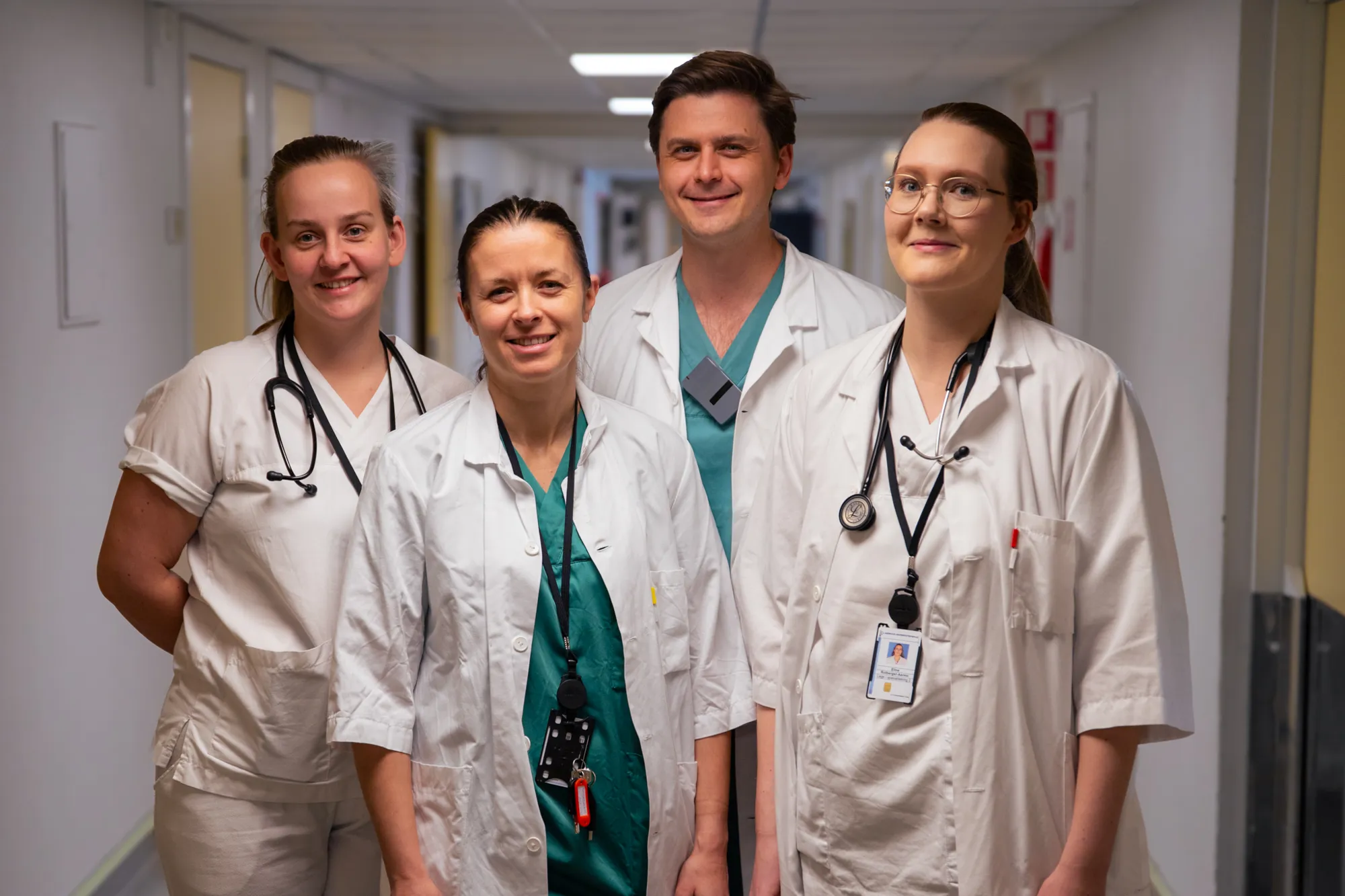 A group of people wearing white lab coats and badges