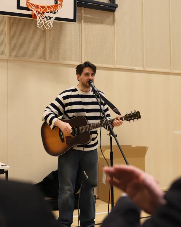 mann spiller gitar og synger