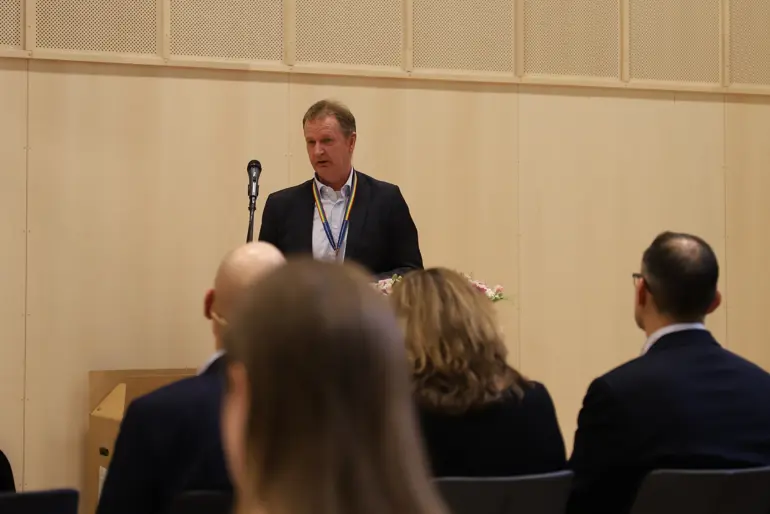En person som snakker til en gruppe mennesker