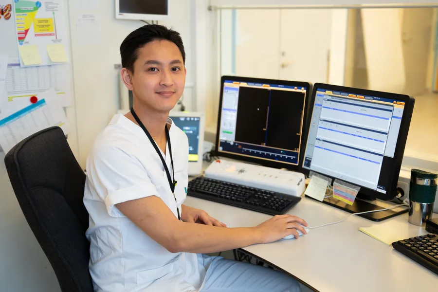En mann som sitter ved et skrivebord med en datamaskin