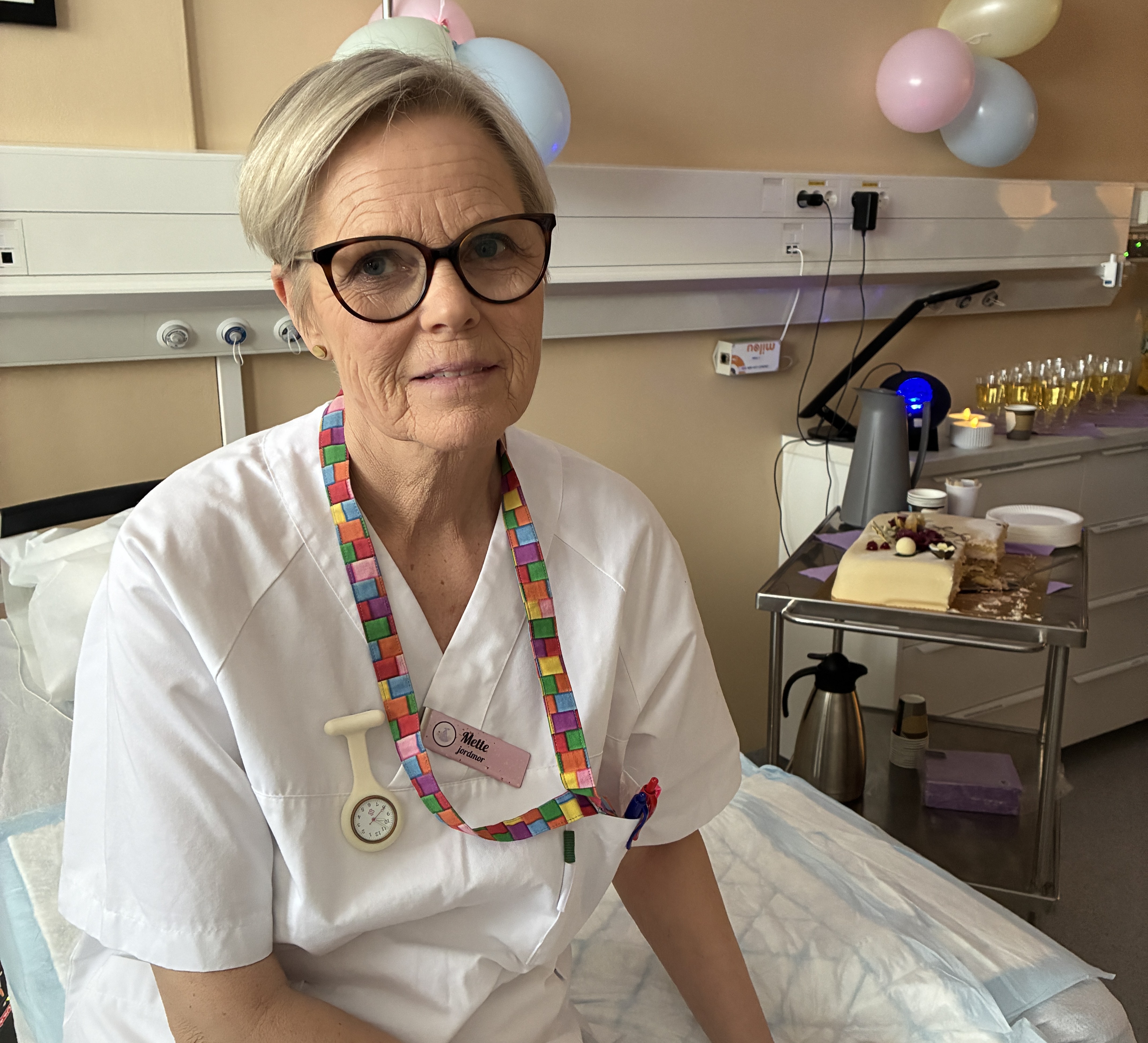 Sykepleier i hvit skjorte og briller