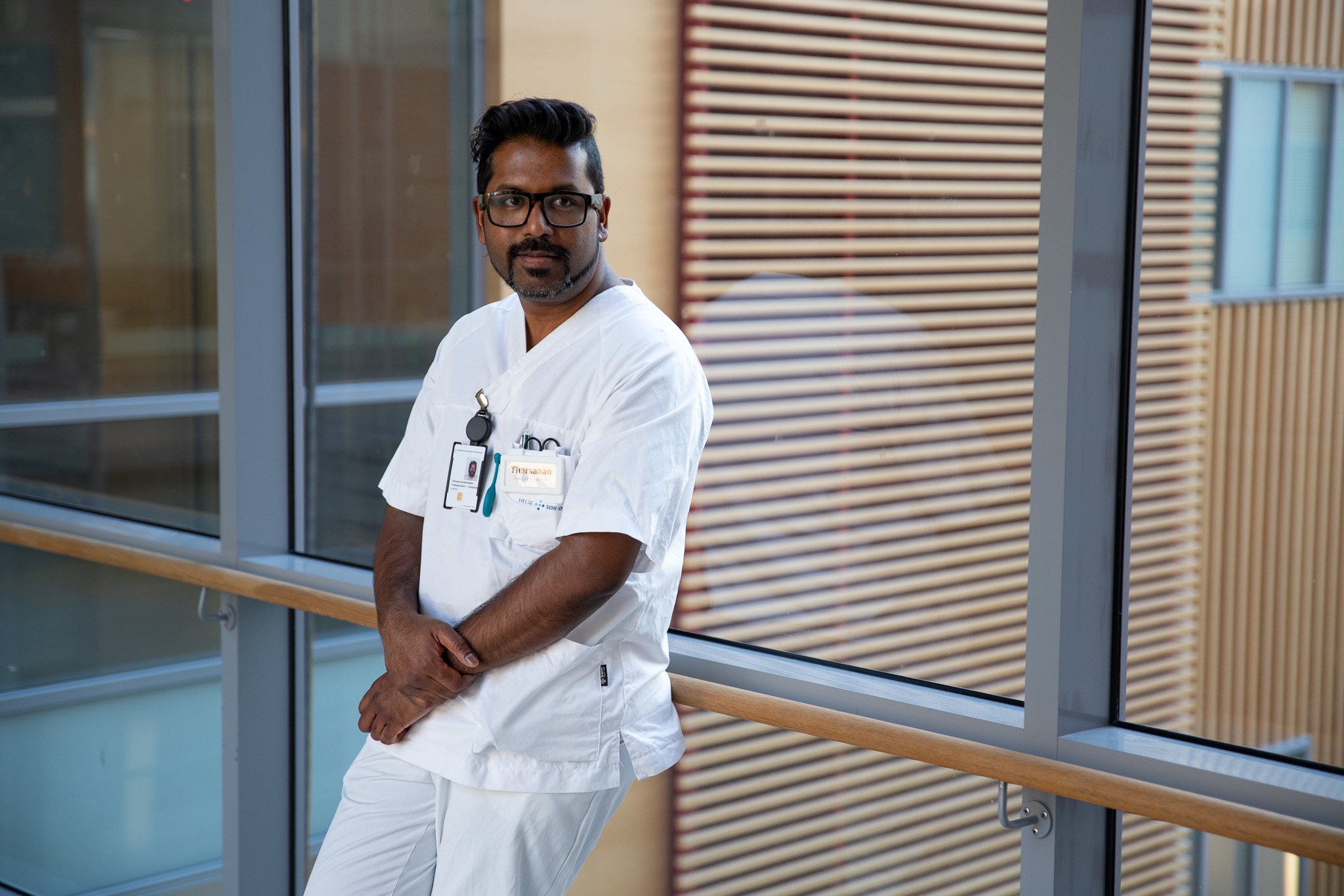 En mann iført hvit frakk og stetoskop