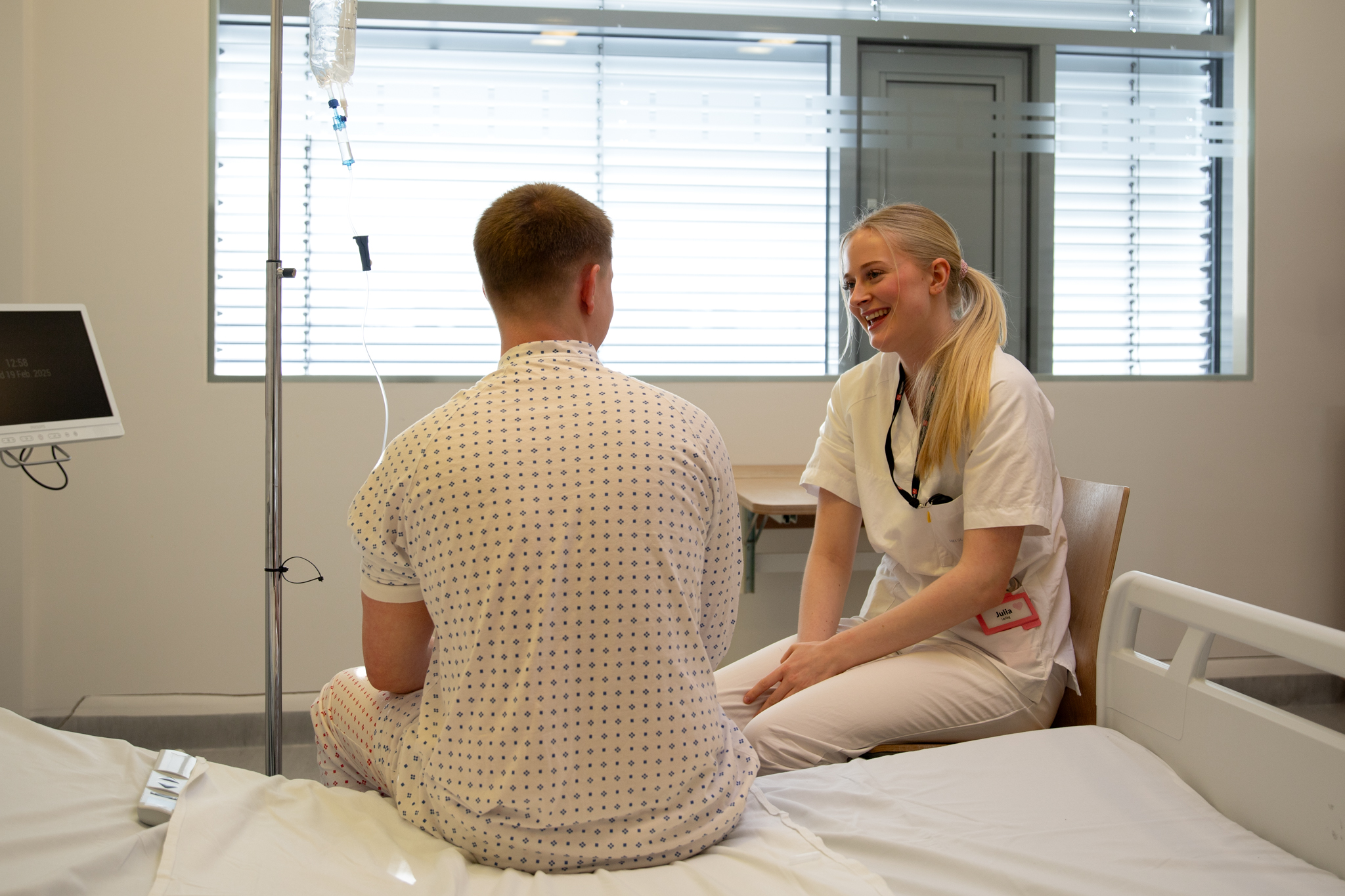 En mann og en kvinne som sitter på en seng