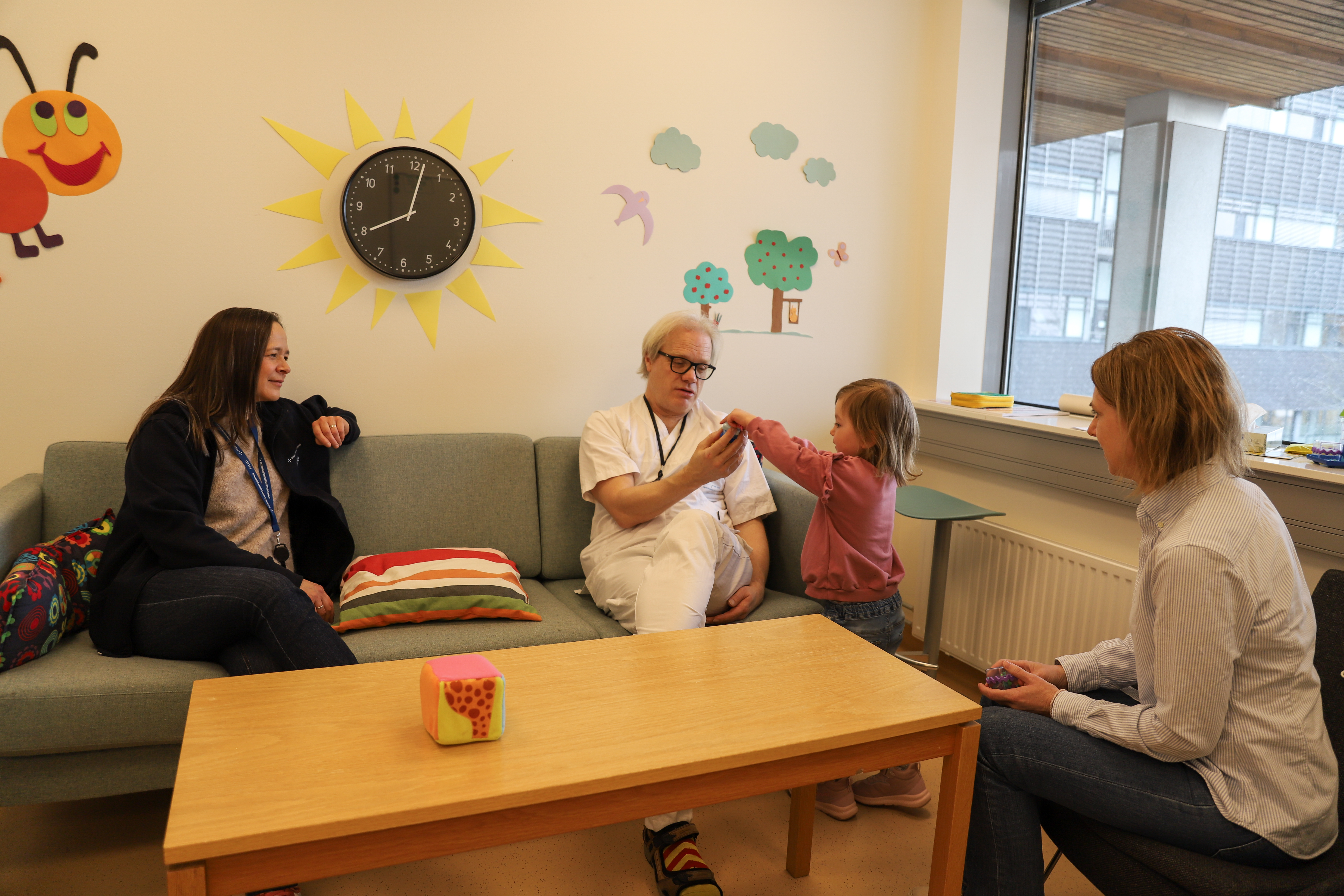 ansatt og lege i samtale med barn og pårørende