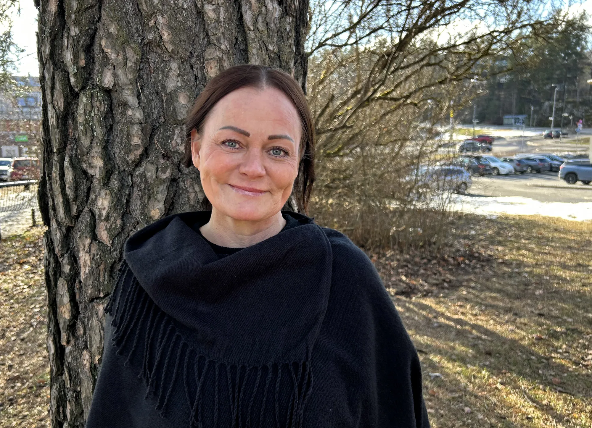 En person som står ved siden av et tre