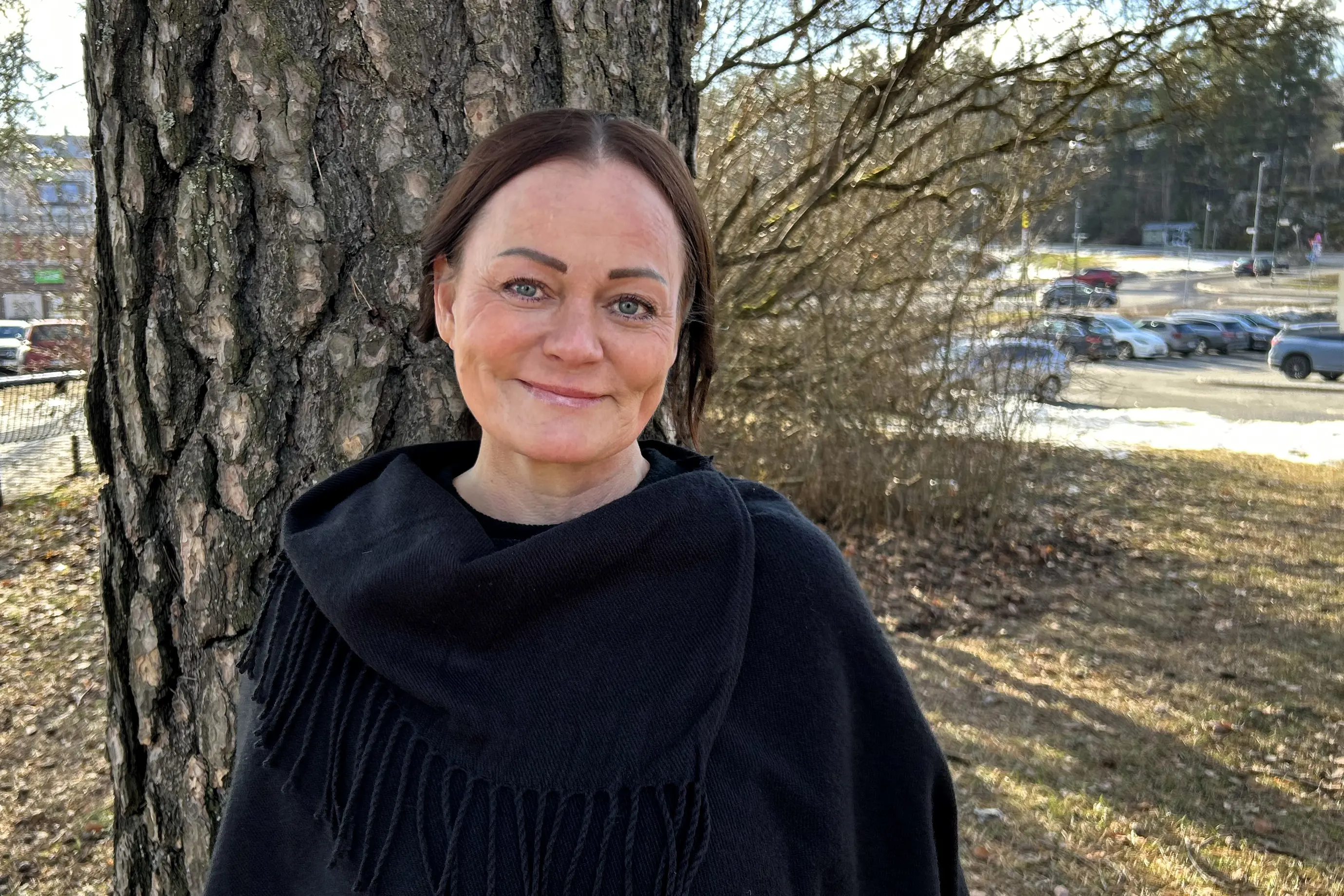 En person som står ved siden av et tre