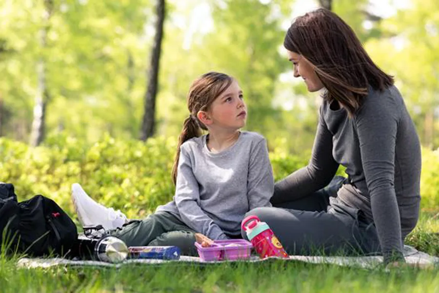 A couple of women sitting on the grass