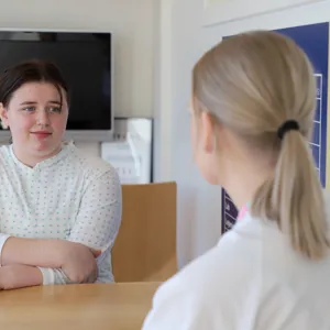 En ungdom prater med en sykepleier