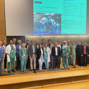 A group of people posing for a photo in front of a large screen