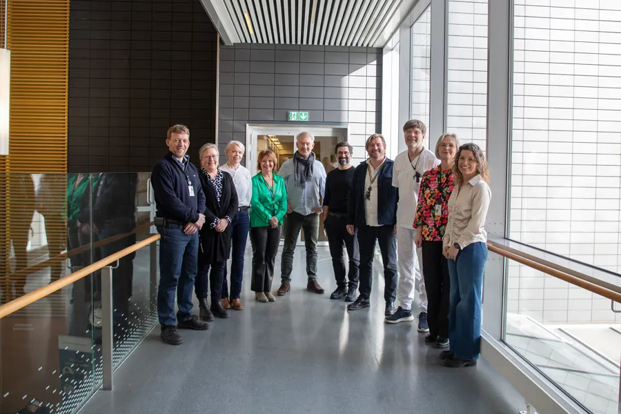 Gruppe mennesker står sammen i sykehusgang.