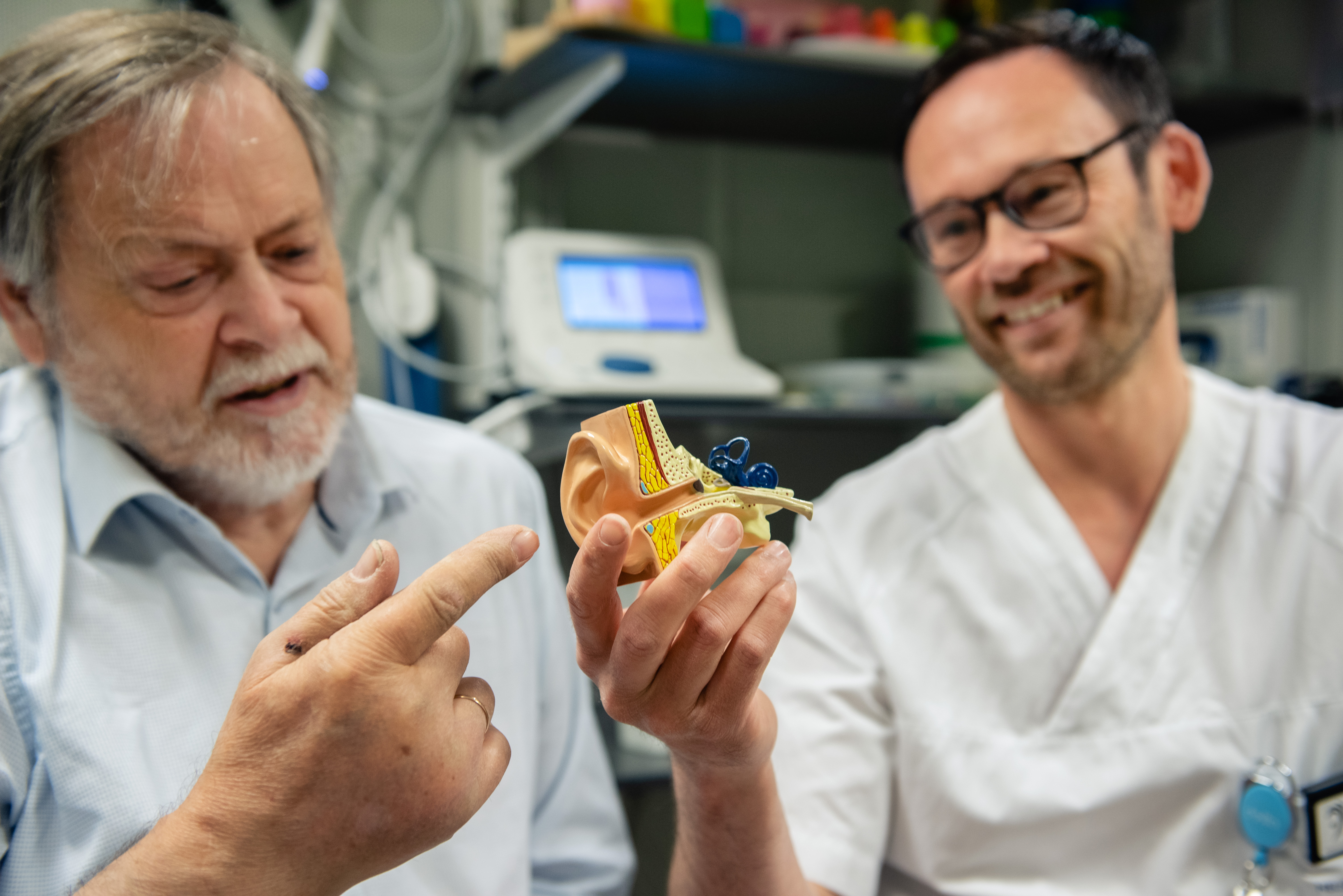 Pasient og helsepersonell ser på en modell av et øre