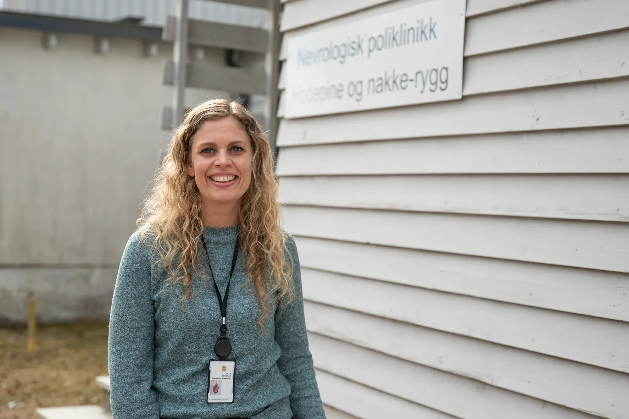 En kvinne som smiler foran poliklinikk