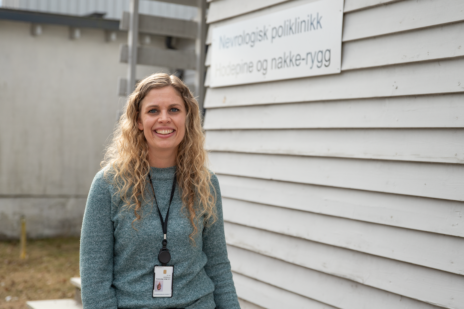 En kvinne som smiler foran poliklinikk