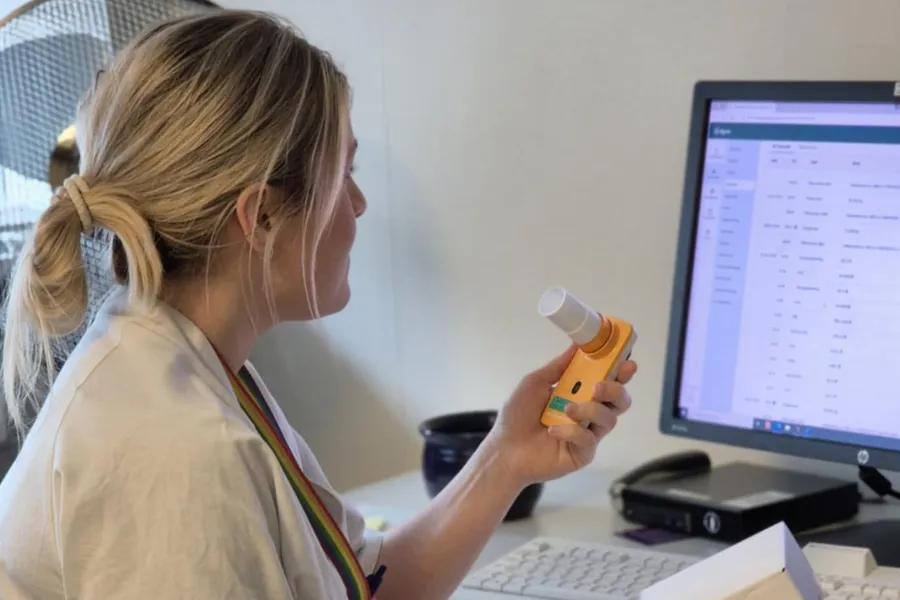 Helsepersonell med et spirometer foran en datamaskin