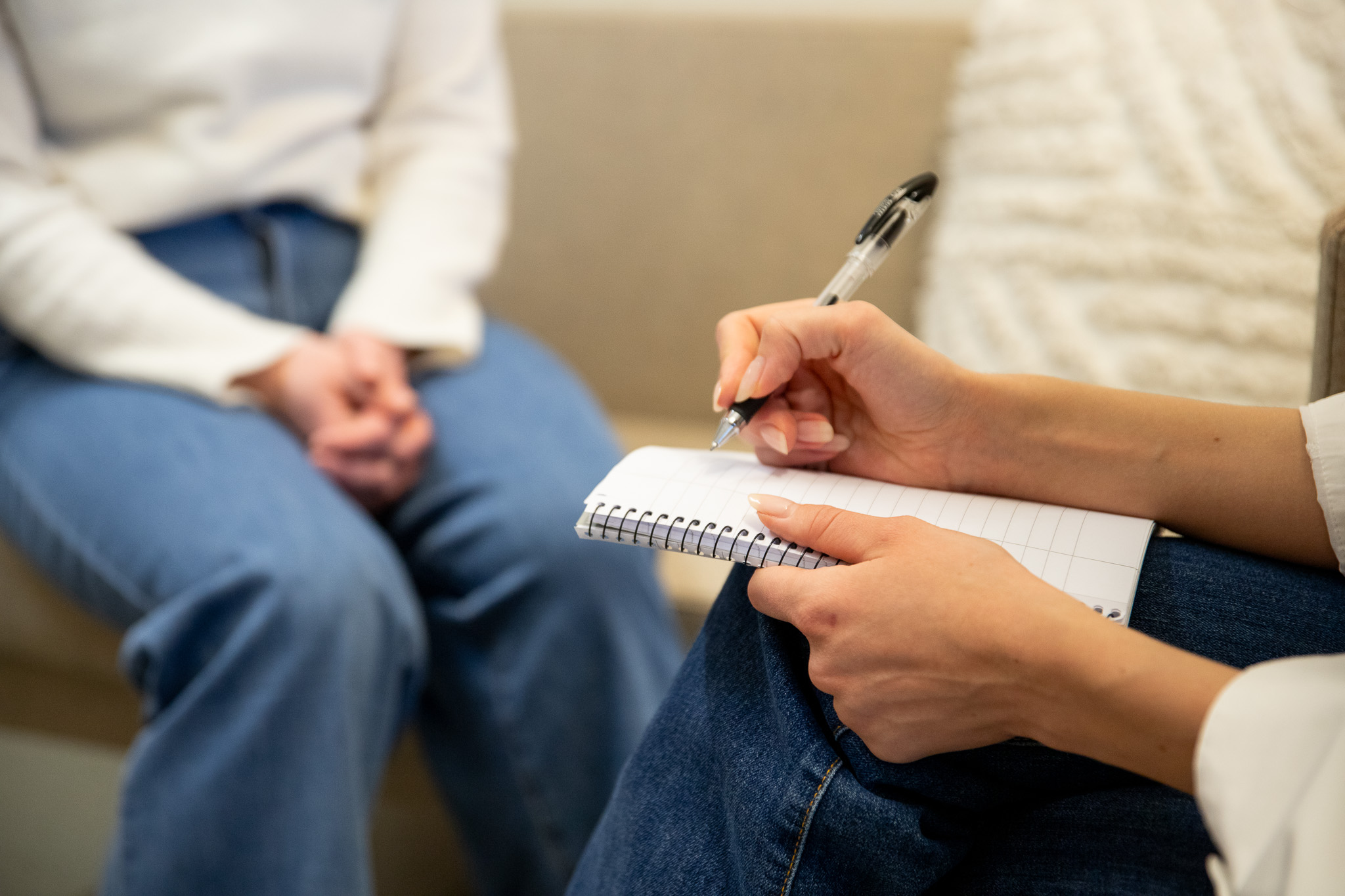 Bilde av en psykolog som noterer i en notatblokk