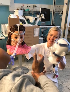 En person som holder dukkehoder for å vise ventilasjonsutstyr