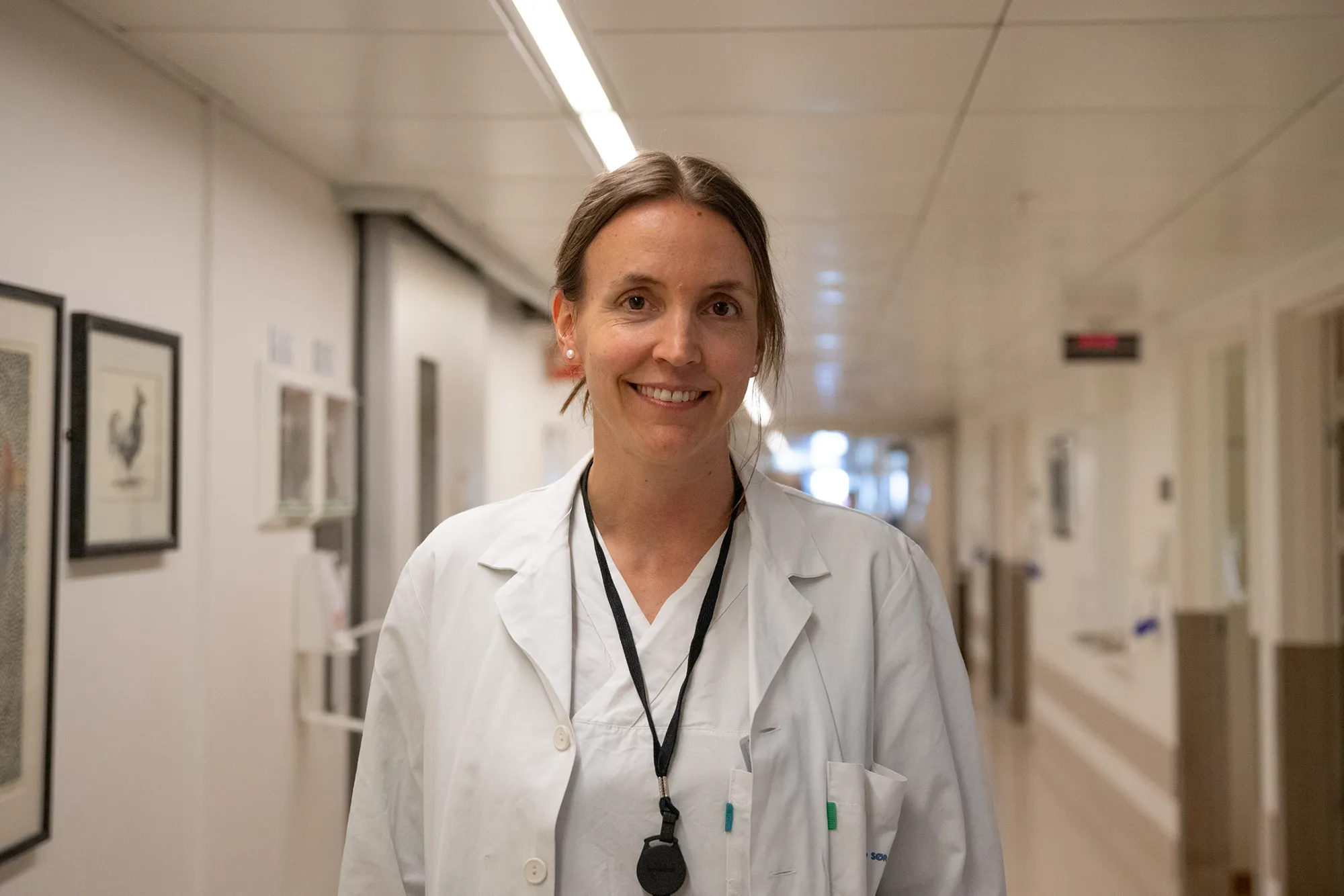 Lege i hvitt tøy smiler mot kamera