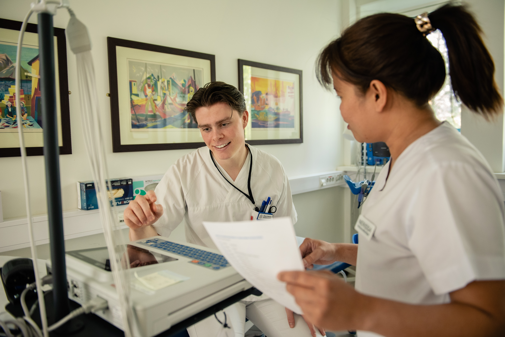 En lege som viser en pasient noe på papiret