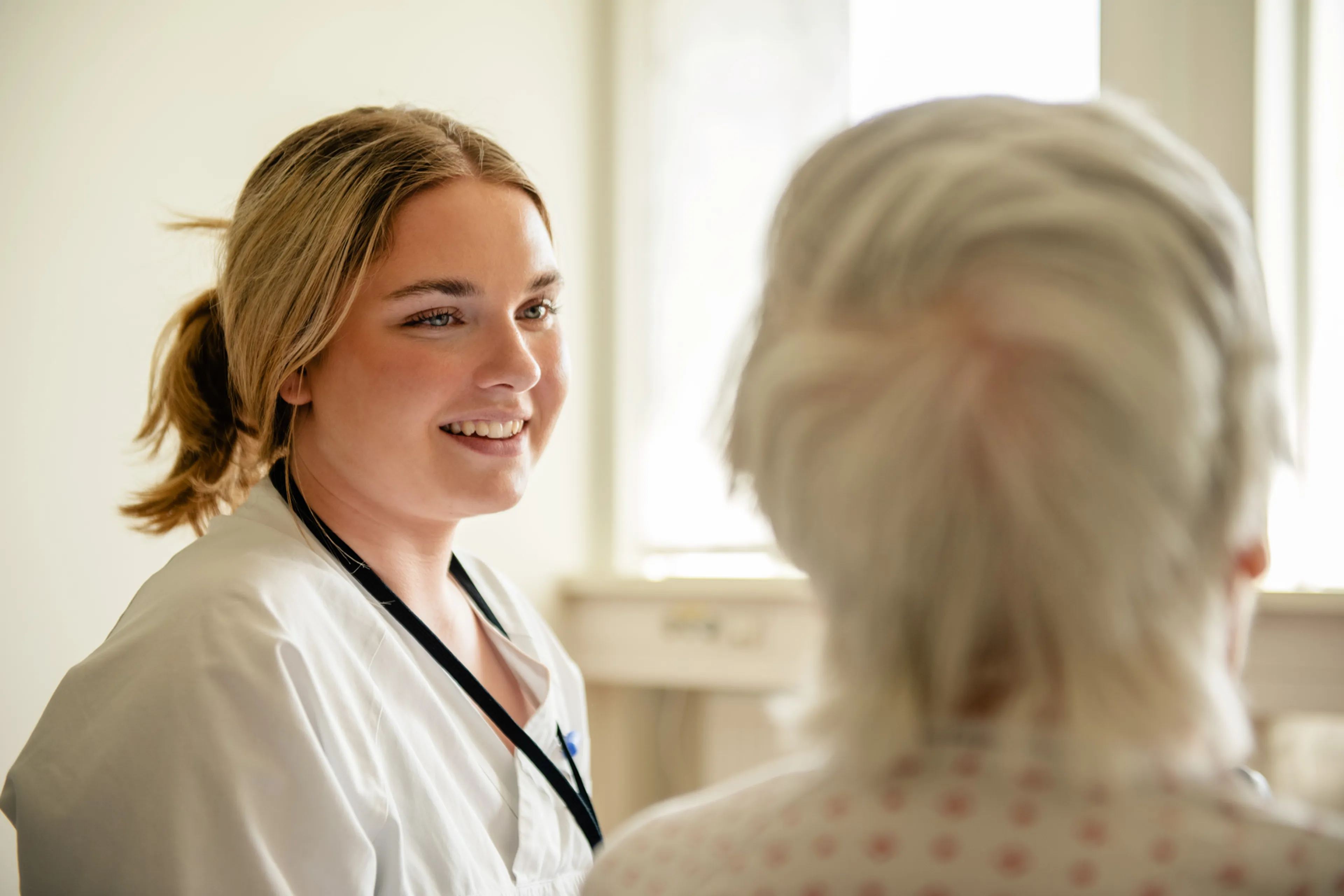 En kvinne som smiler til en annen kvinne