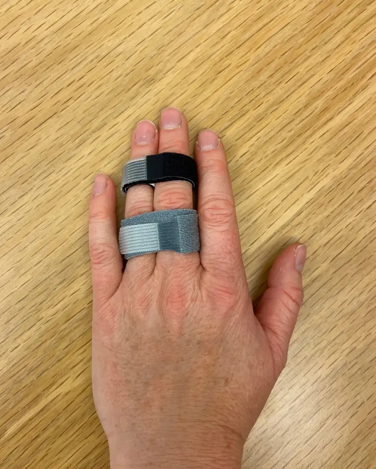 A hand holding a small metal object