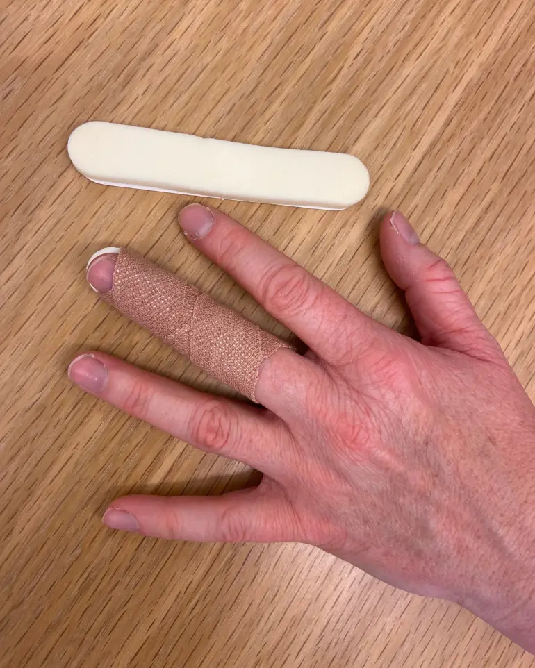 A person's hand holding a white object
