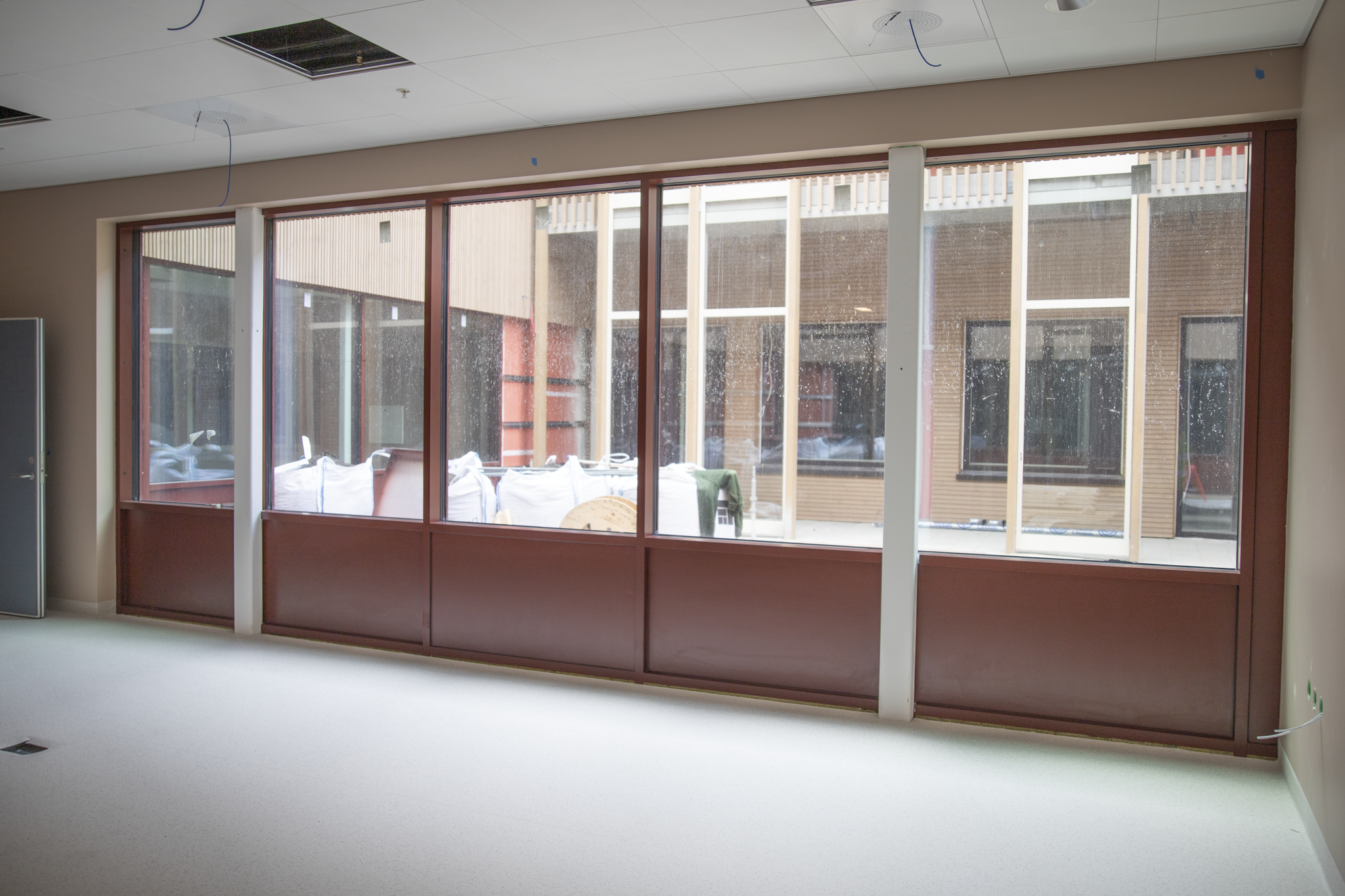 Et rom med en sofa og et bord med stoler og et vindu med mange vinduer