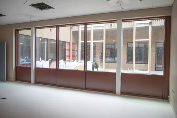 Et rom med en sofa og et bord med stoler og et vindu med mange vinduer