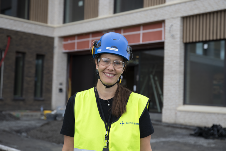 En dame som bruker hjelm utenfor byggeplass
