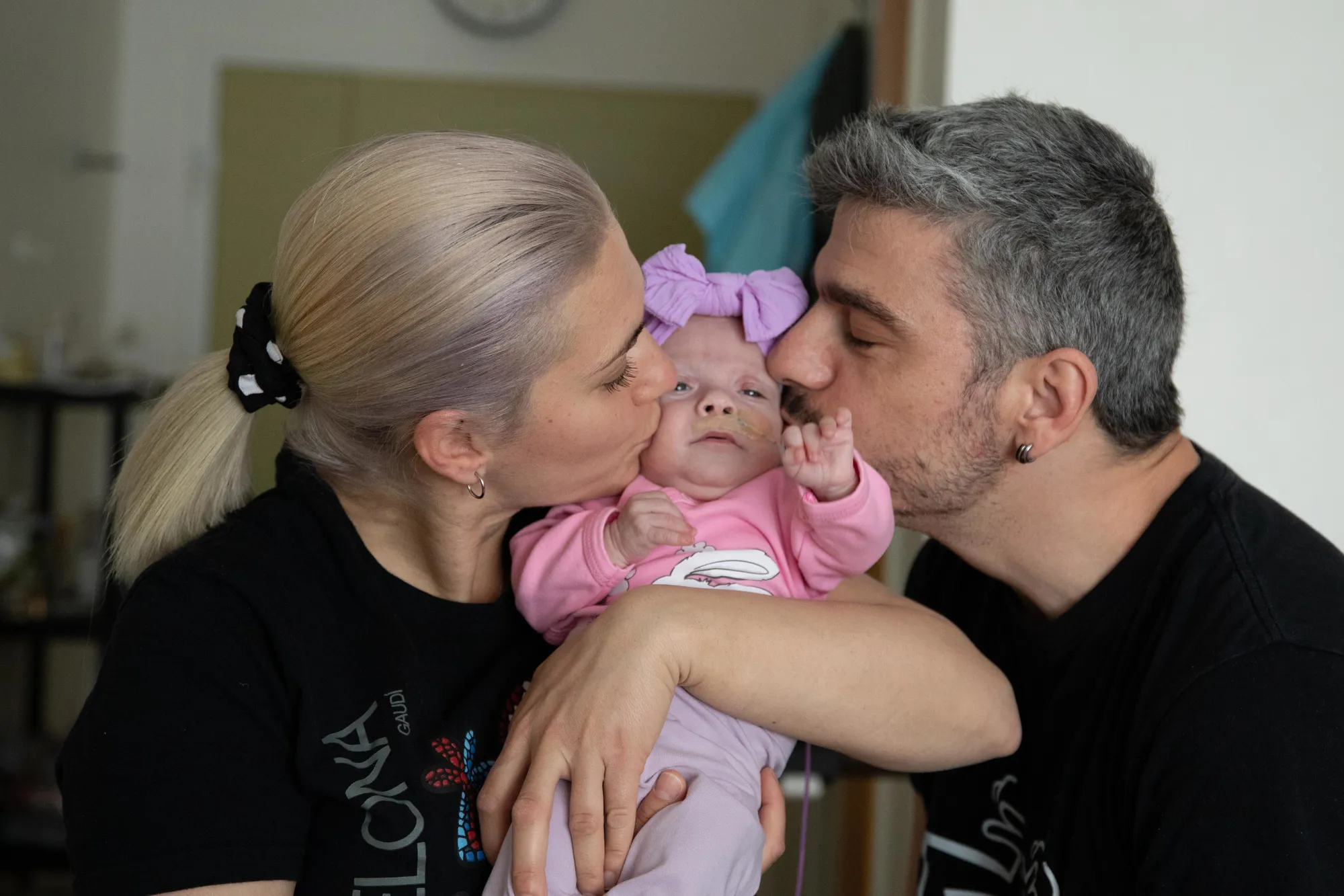 En mann og kvinne som kysser en baby