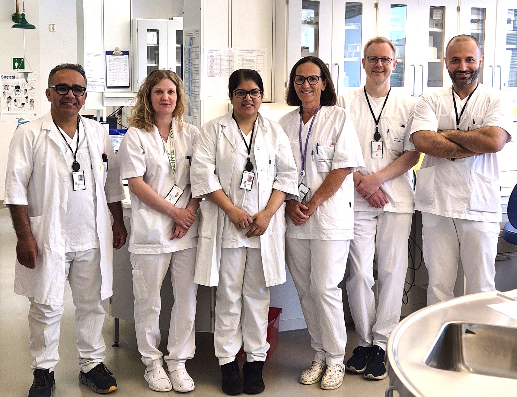 En gruppe mennesker iført hvite laboratoriefrakker og stetoskoper