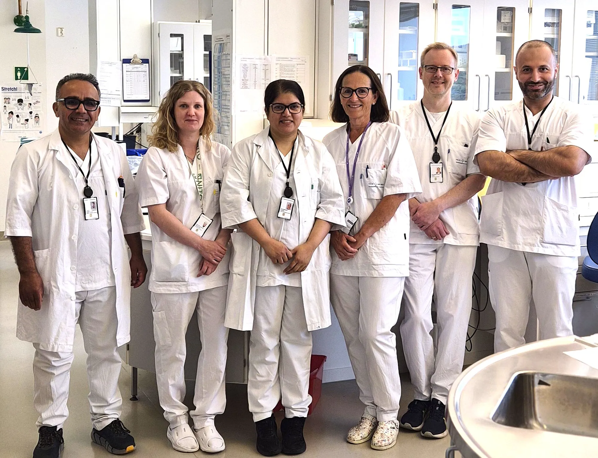 En gruppe mennesker iført hvite laboratoriefrakker og stetoskoper