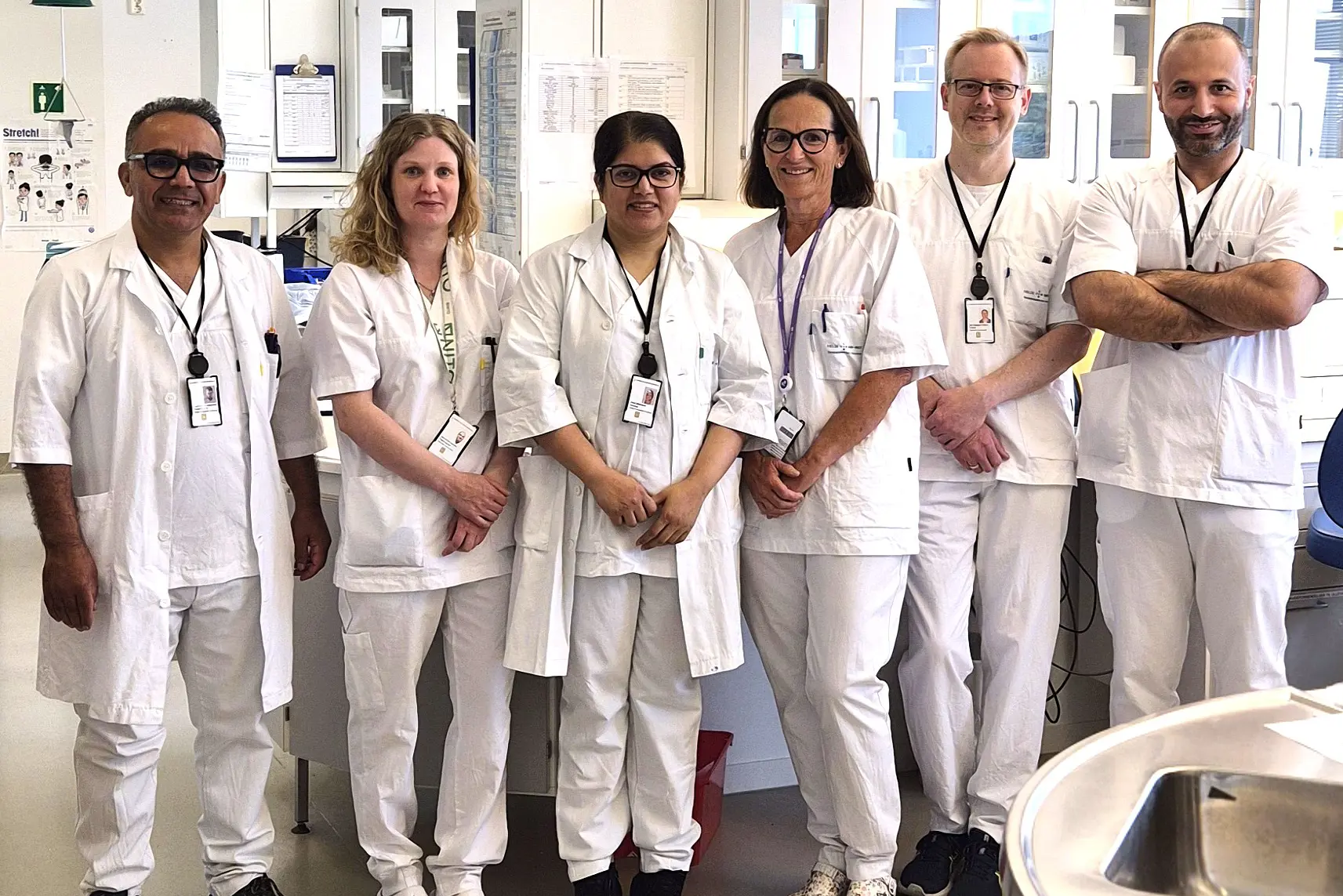 En gruppe mennesker iført hvite laboratoriefrakker og stetoskoper