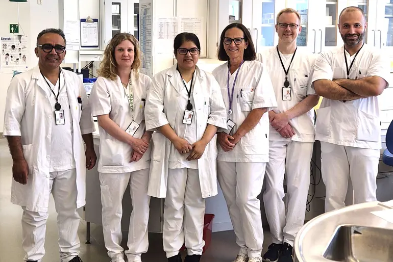 En gruppe mennesker iført hvite laboratoriefrakker og stetoskoper