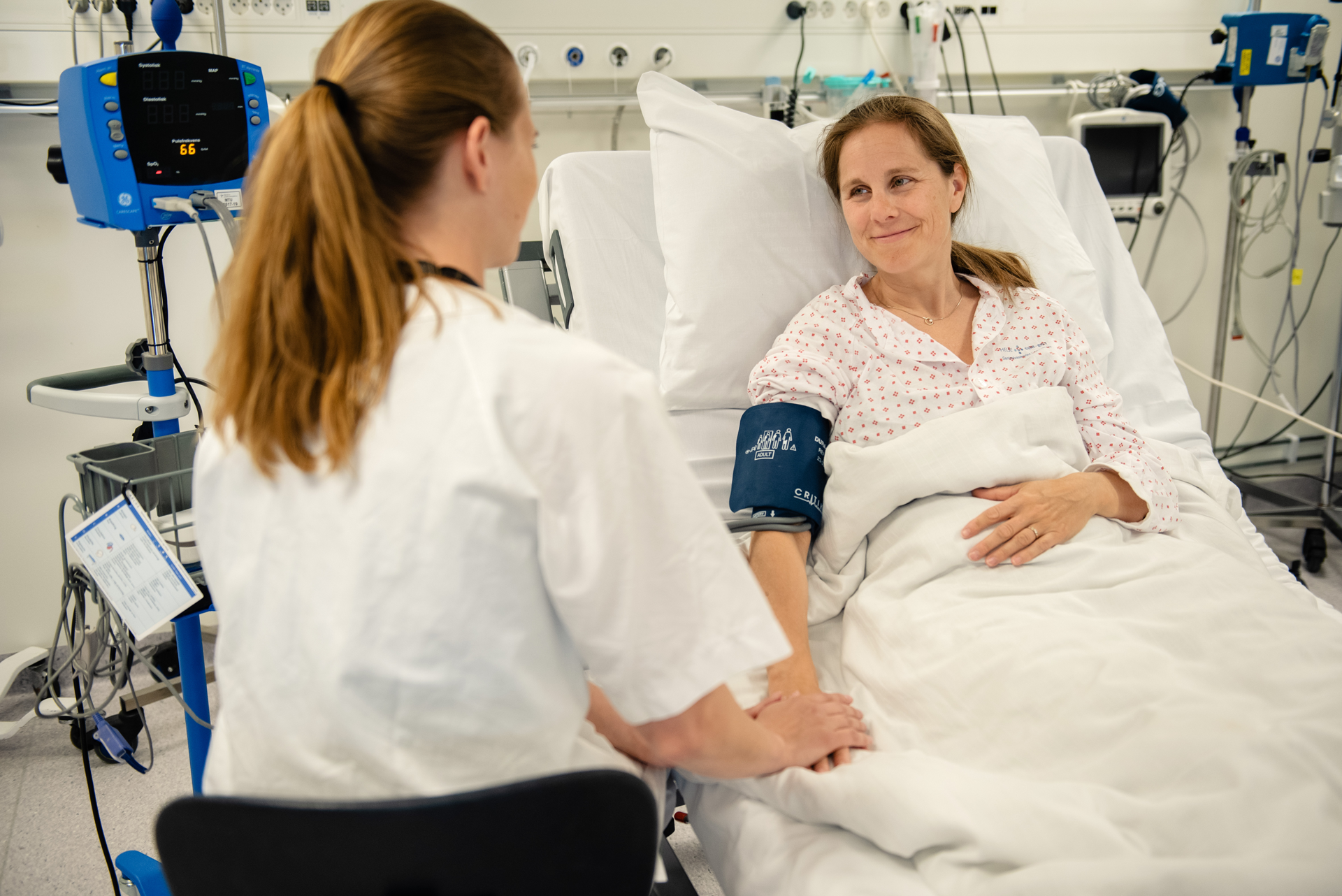 En person i en sykehusseng med en person i en sykehuskjole