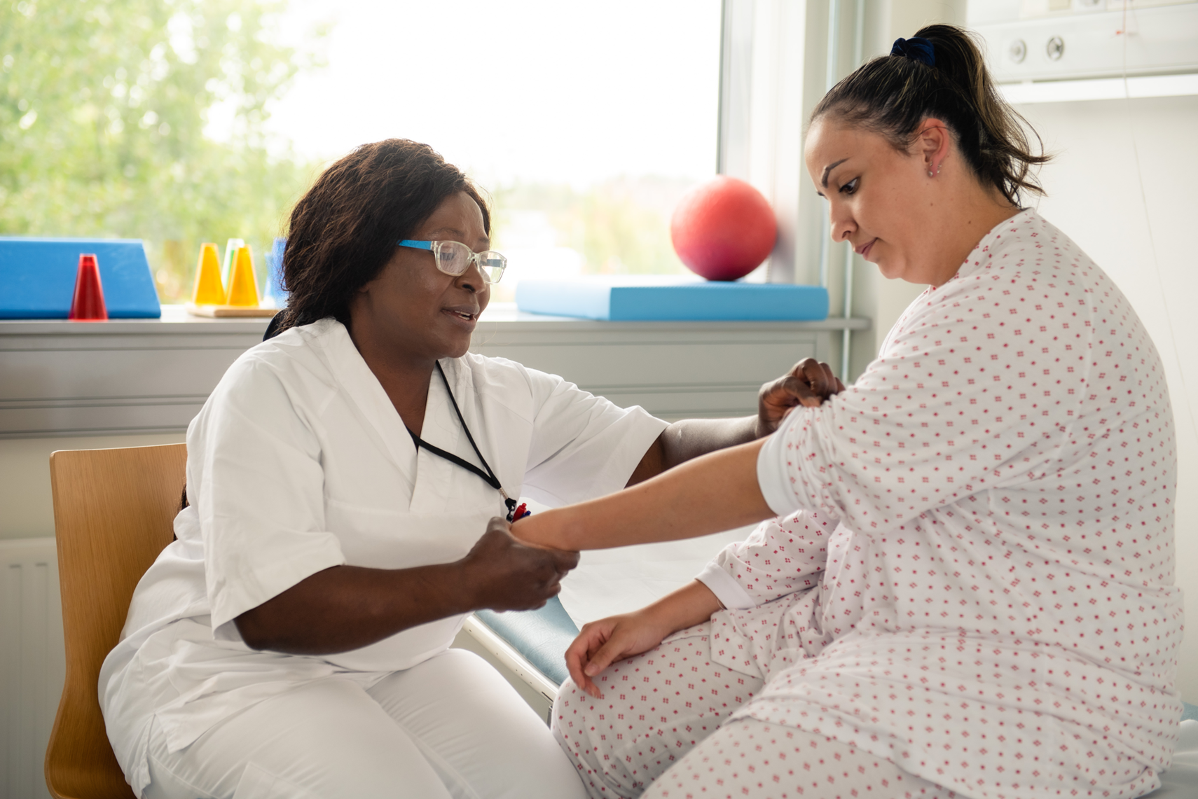 En lege som sjekker pasientens puls