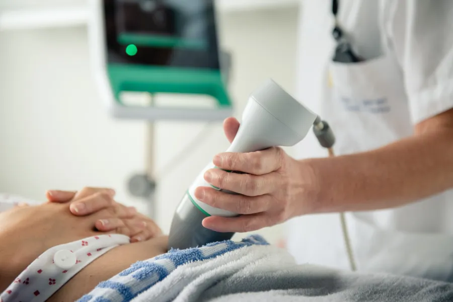 En lege som bruker et stetoskop for å måle pulsen