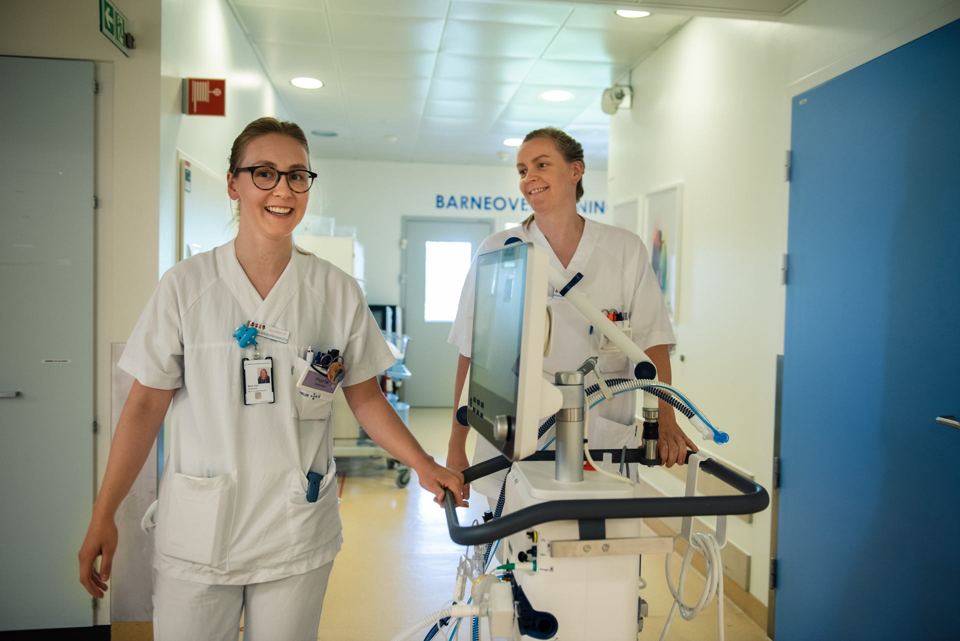 Et par menn i hvite laboratoriefrakker som står ved siden av en maskin