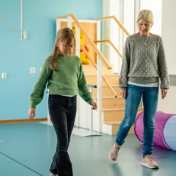 En kvinne som står ved siden av en kvinne i et rom