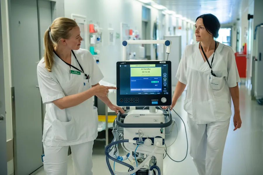 A couple of women in white coats looking at a computer screen