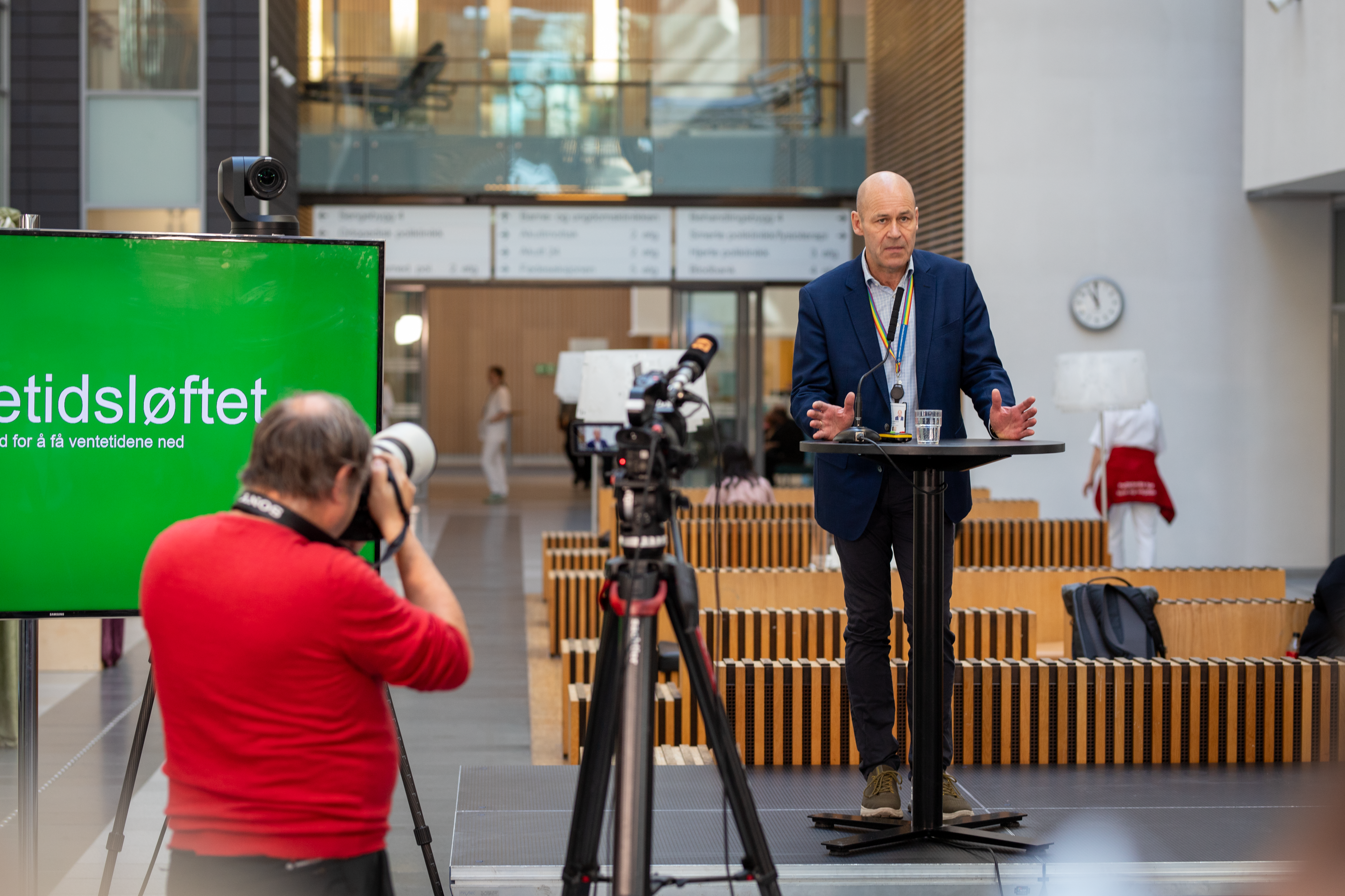 en journalist tar et bilde av en mann på et podie