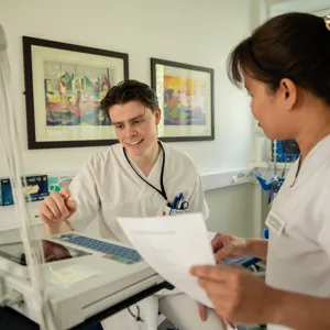 En sykepleier som viser en kollega en maskin