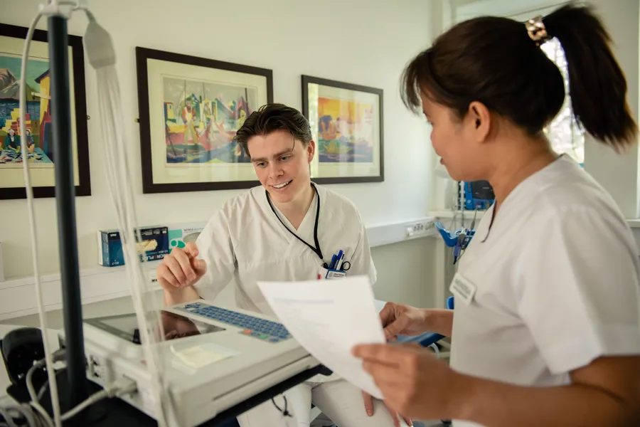En sykepleier som viser en kollega en maskin